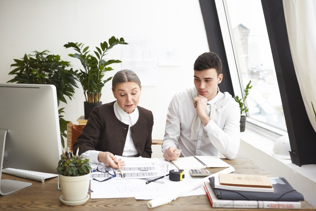 people-job-teamwork-cooperation-concept-two-professional-engineers-colleagues-sitting-desk-with-blueprints-computer-engineering-tools-discussing-plans-ideas-having-serious-looks_344912-1621.jpg